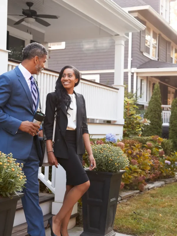 Business Couple Leaving Suburban House For Commute To Work